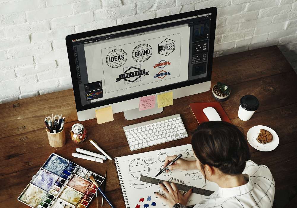 a logo designer at his desk working on a design to change their logo for the company