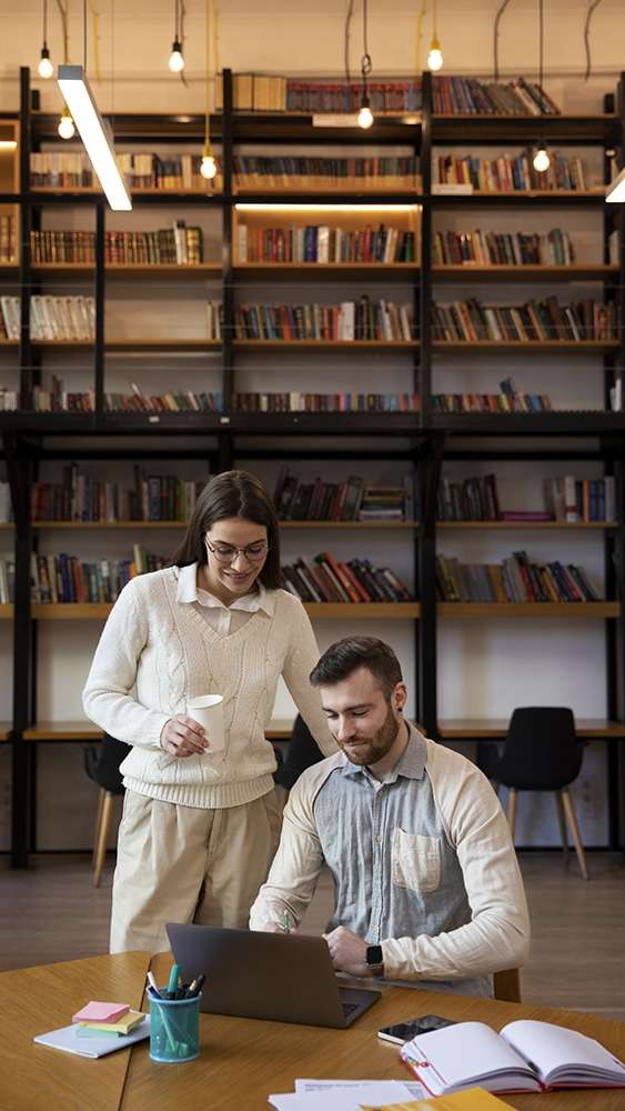 a male and female marketing professional looking at a laptop screen