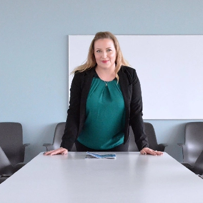 picture of a corporate woman leaning over a conference table