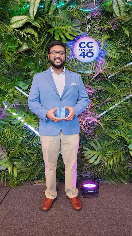 Musanna Al-Muntasir smiling and holding his 2024 Corpus Christi 40 under 40 award