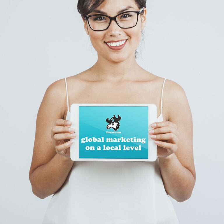 a woman with glasses holding up a tablet with ItsMoose.com's tagline/slogan