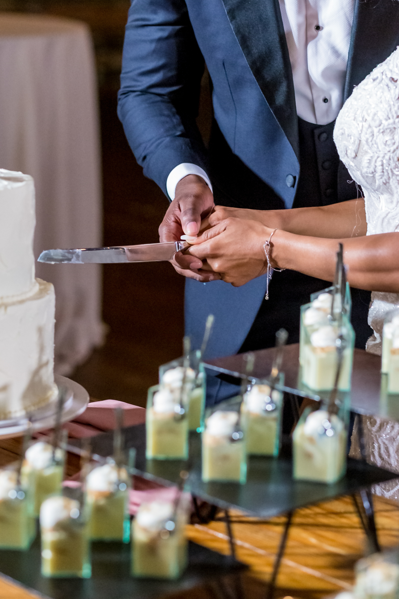 a closeup for a couple cutting a wedding cake for an event marketing page