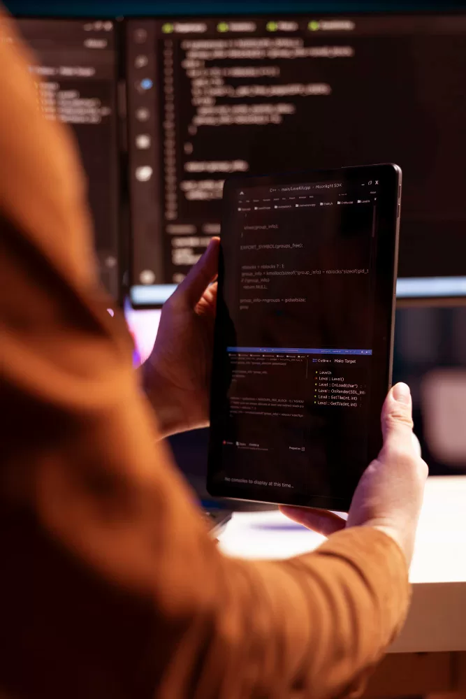 closeup of a digital marketer looking at custom website design code on a tablet at a desk